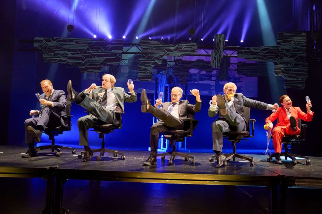 Kuusi henkilöä istuu toimistotuoleilla ja tanssii, kuvituskuva Nokia-näytelmästä.